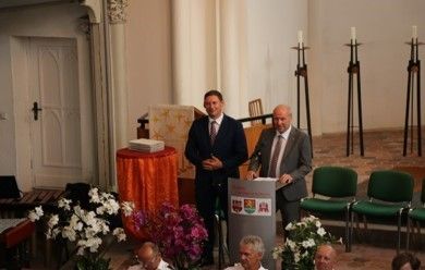 Bild: zwei Männer in der Kirche am Rednerpult