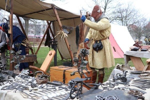 Zdjęcie: starodawnie ubrany mężczyzna sprzedający towary na targu historii