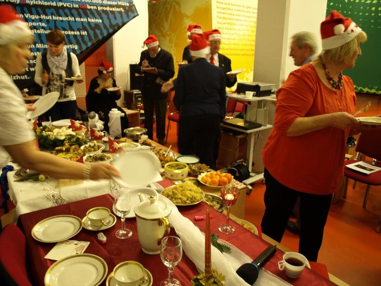 Bild: Weihnachtsbacken-Büfett und Menschen mit Nikolausmütze