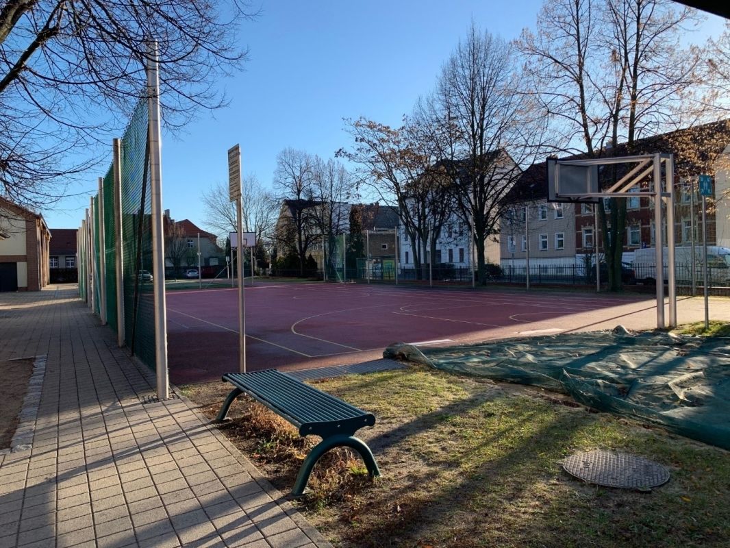 (1) Schulgebäude und Turnhalle mit Gedenktafel