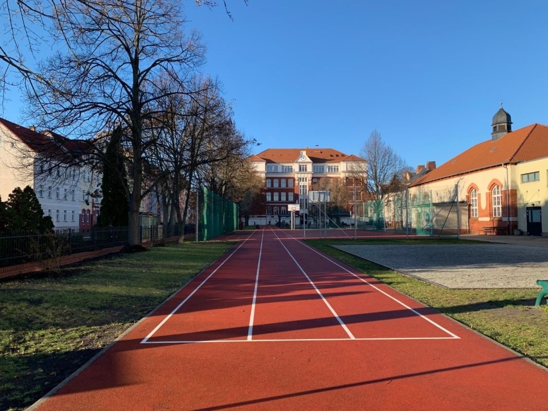 Budynek szkoły i sala gimnastyczna z tablicą pamiątkową